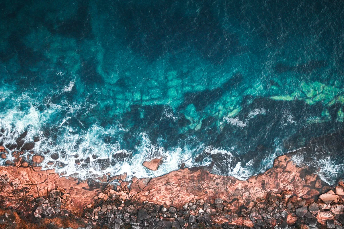 Waves breaking on a rocky coastline, from above